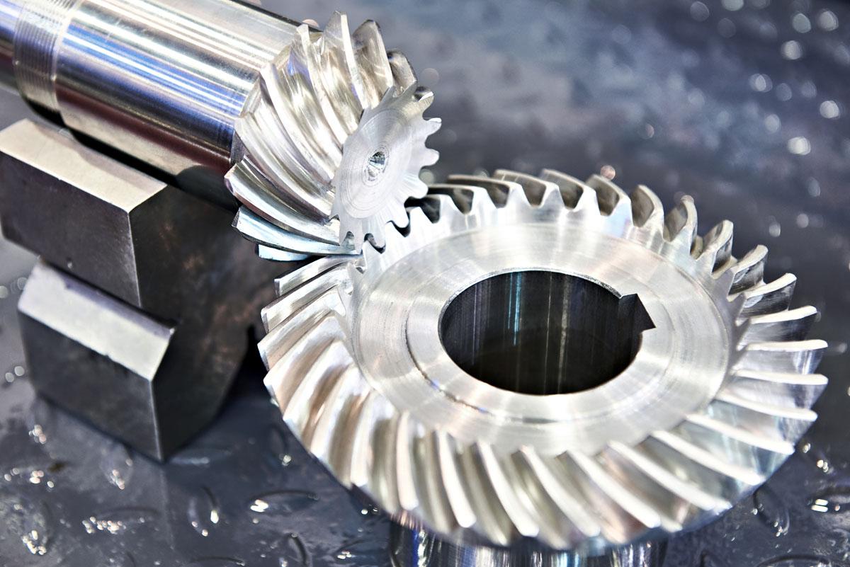 spiral bevel gear is shown engaging with a beveled shaft
